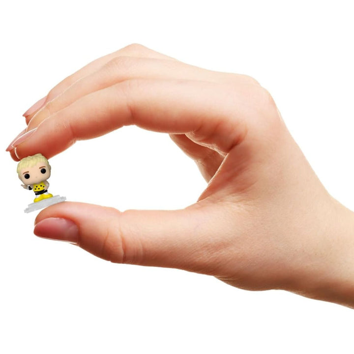 Hand holding a small dusty rhodes figurine against a white background