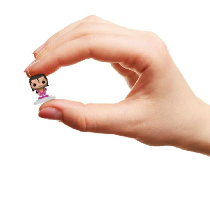 Hand holding a small razor ramon figurine against a white background