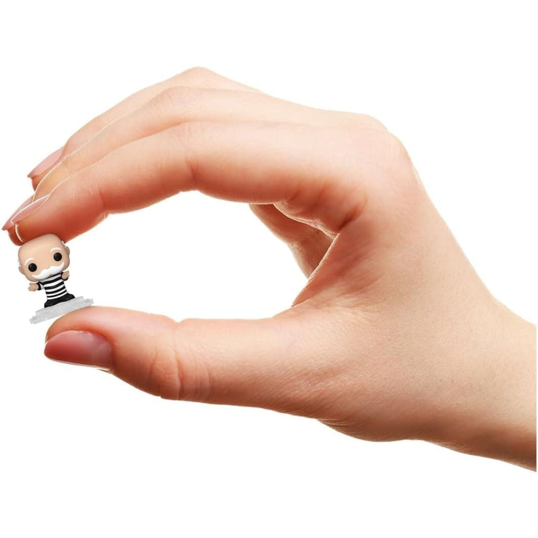 Hand holding a small mr monopoly figurine against a white background