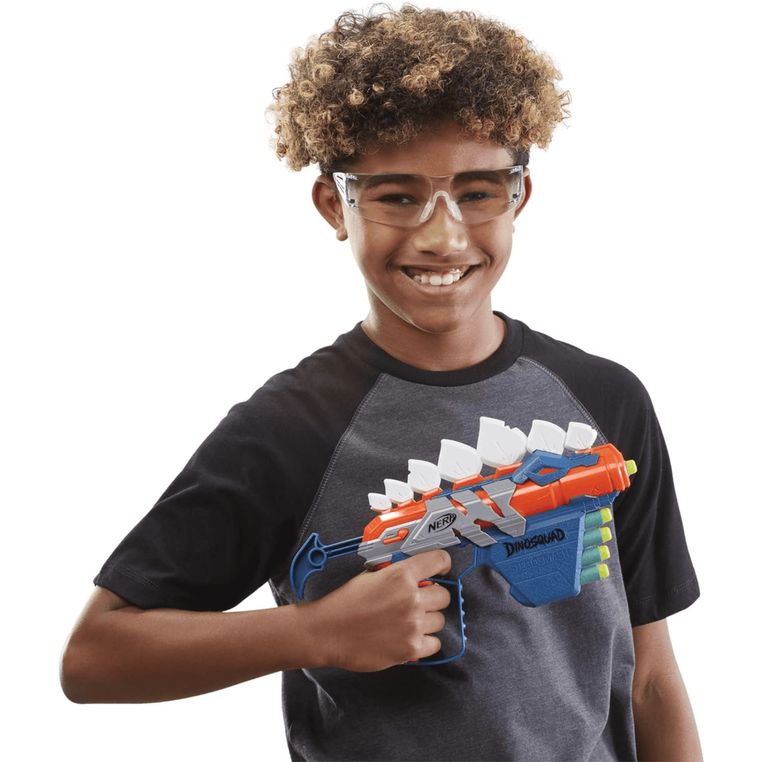 young boy wearing protective glasses holding the dinosquad nerf blaster gun