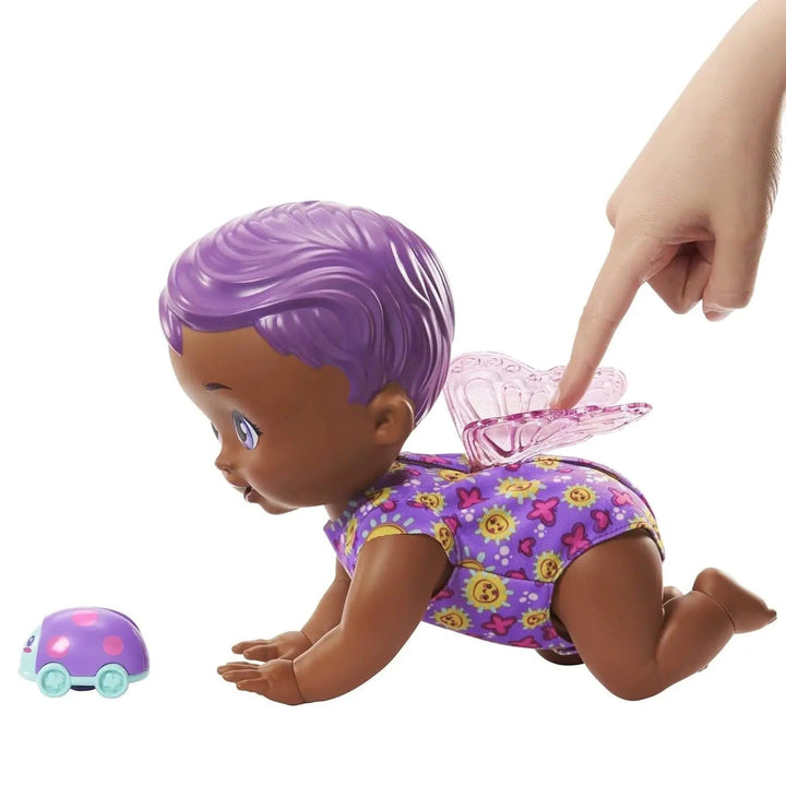 Finger pressing the wings on purple butterfly baby to make the doll crawl