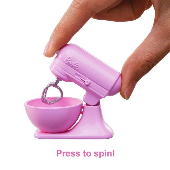 Pink food mixer with finger pressing the button to make it spin