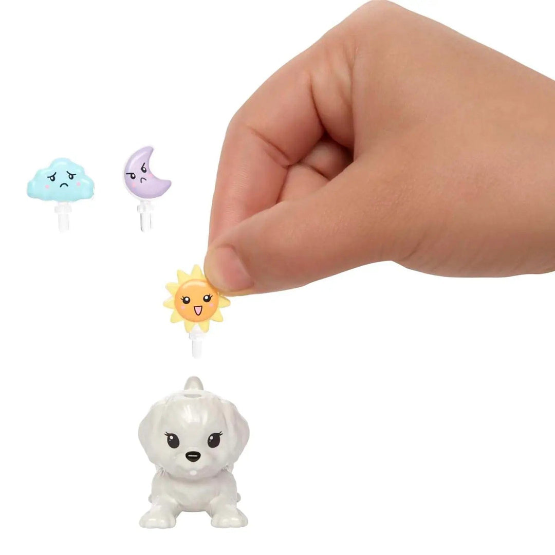 Finger holdng a sunshine emoticon to put in Barbie's white puppy's head