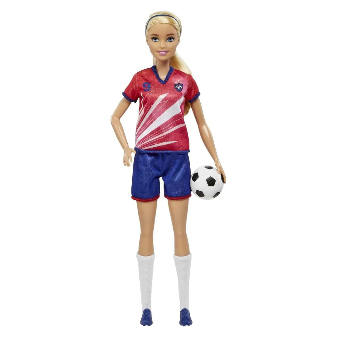 Barbie football player in red jersey and blue shorts, carrying a soccer ball