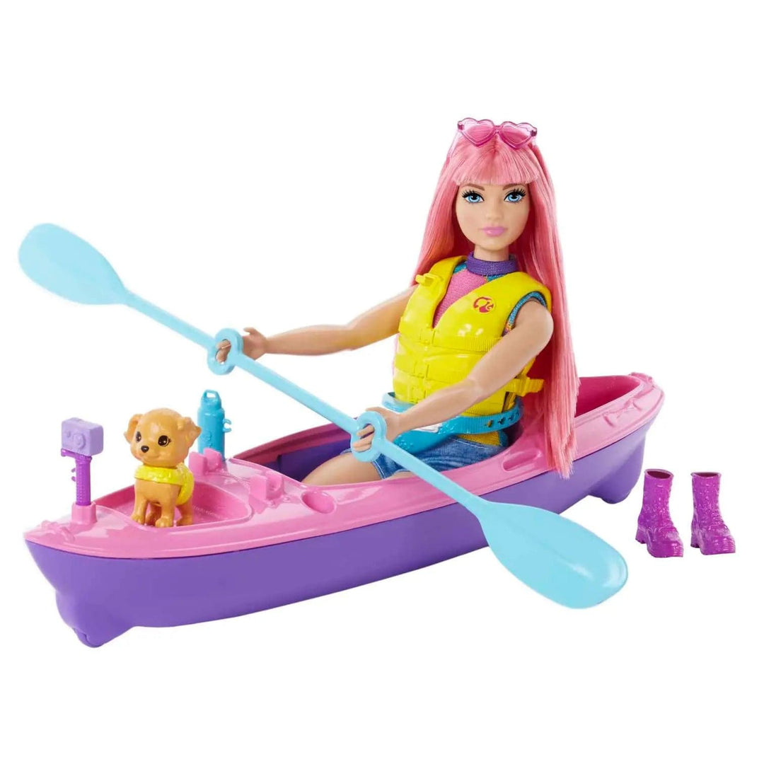 Camping Barbie sitting in her kayak holding the paddle, with puppy sitting at the front