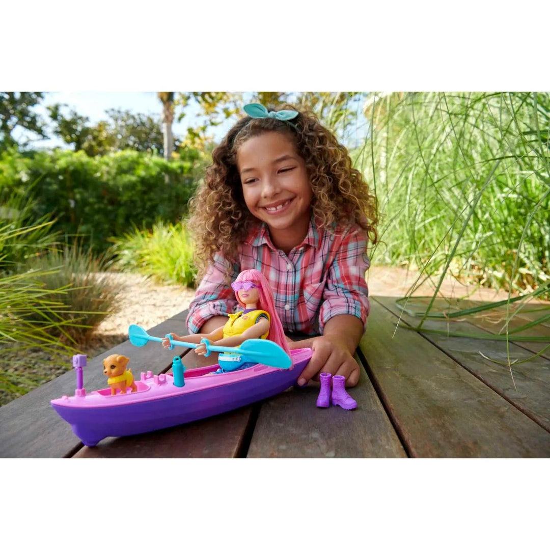 Girl playing with Barbie in a kayak, with puppy and purple hiking boots