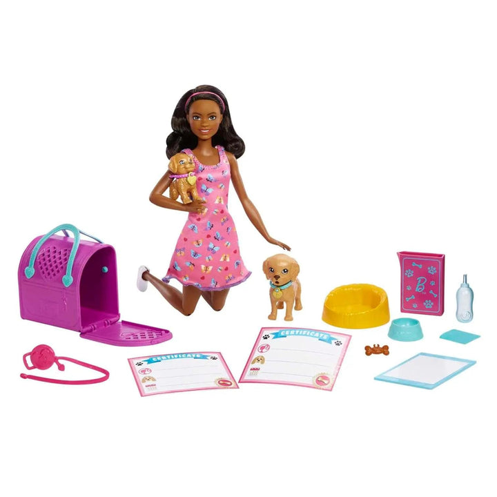 Barbie doll kneeling beside a pet carrier and puppy, with pet accessories laid out on white background