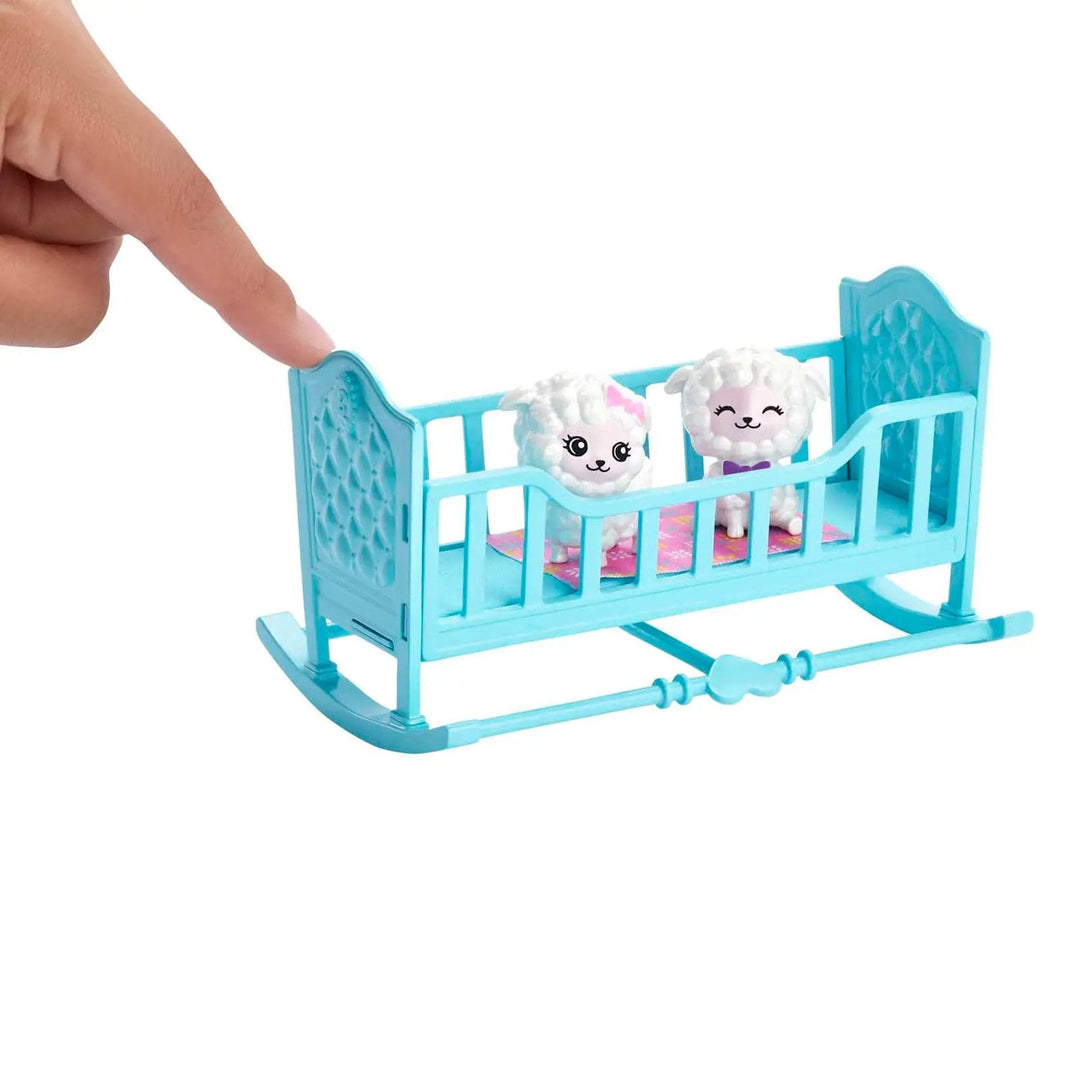 2 lambs in a blue cot being rocked by a hand