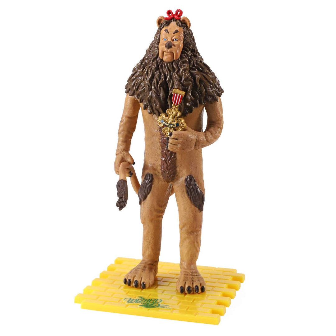 A collectible action figure of the the Cowardly Lion from The Wizard of Oz, standing on a yellow brick road base against a plain white background.