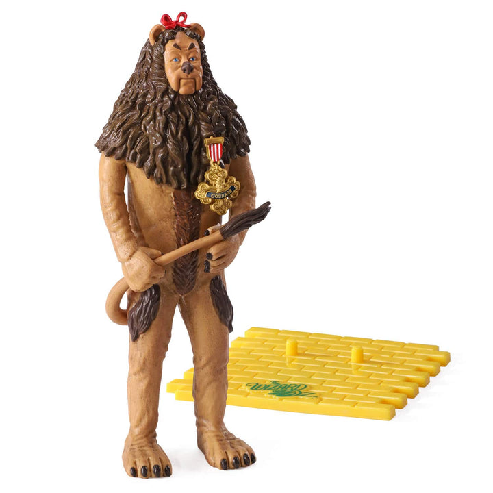 A collectible action figure of the the Cowardly Lion from The Wizard of Oz, standing beside a yellow brick road base against a plain white background.