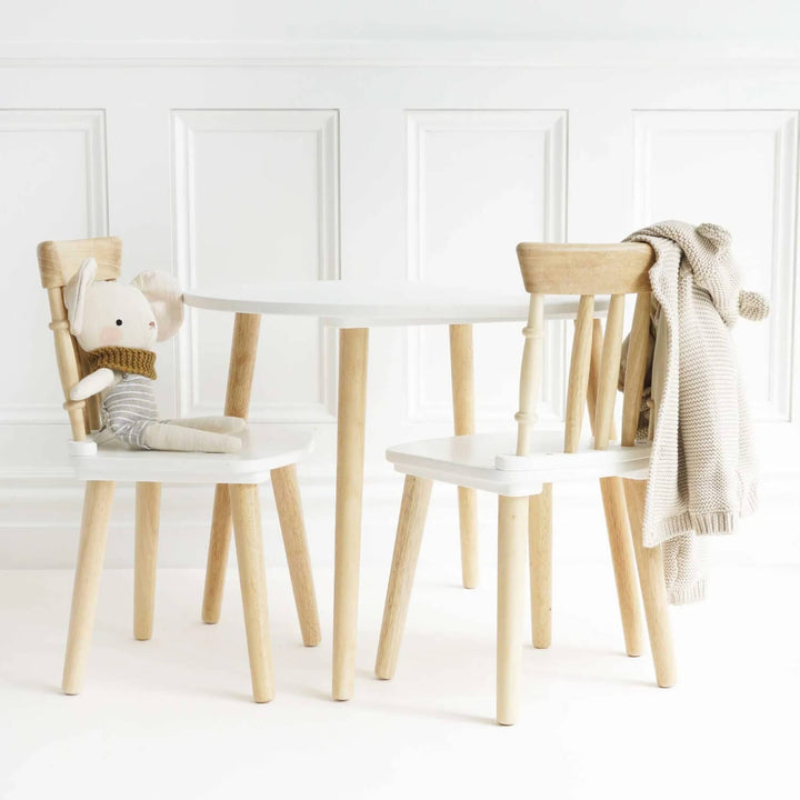 Kids whote table and chiars set with a soft toys and clothing on the chairs