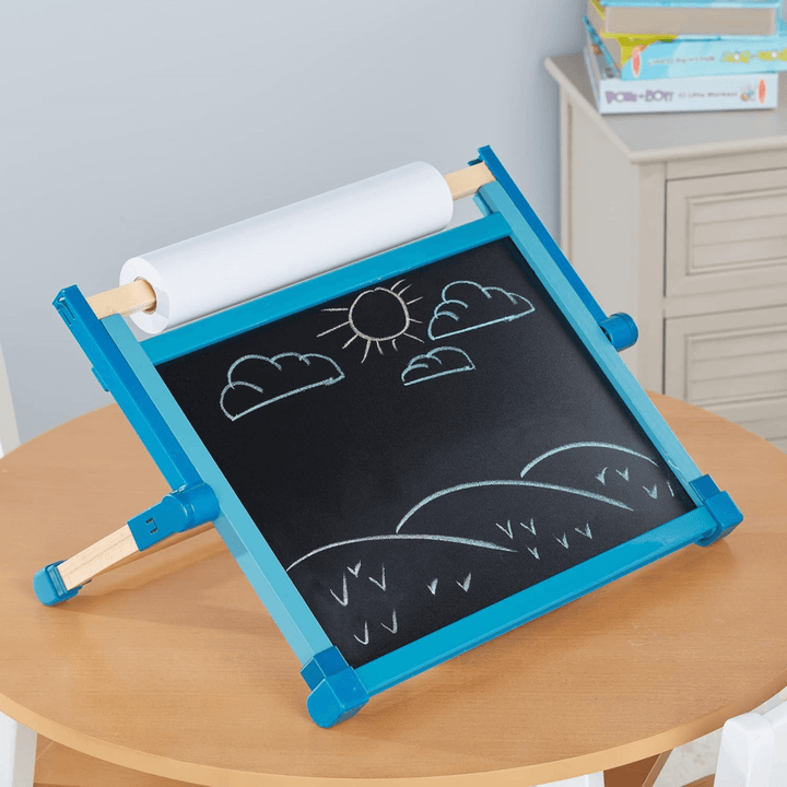 tabletop easel on top of a wooden table in kids bedroom with books in the background