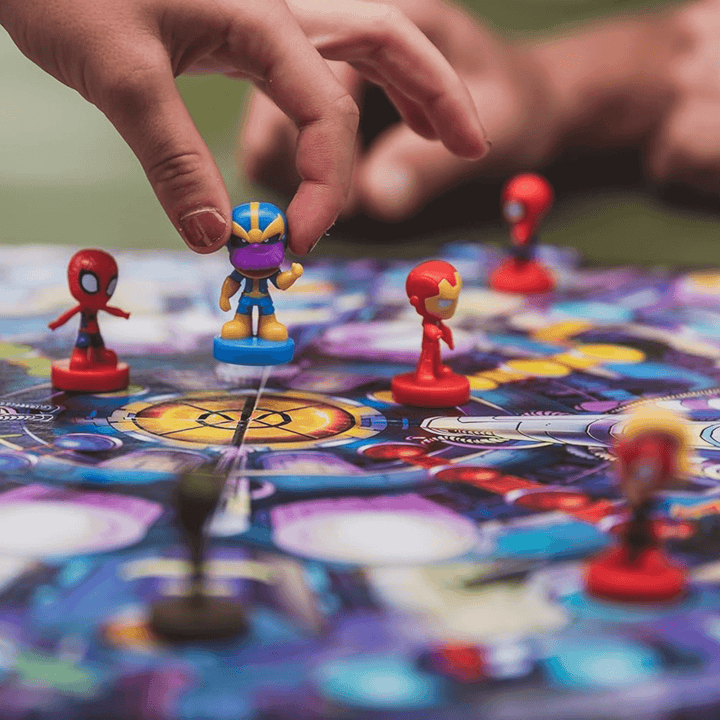 a hand placing thanos onto the centre of the board game