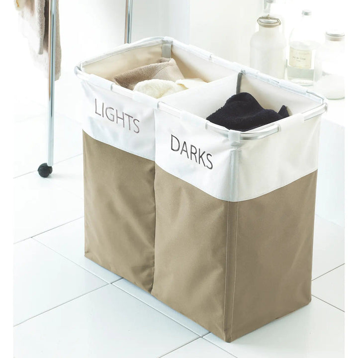 Natural and white laundry basket with 2 compartments printed with Lights and Darks, on a white tiled floor