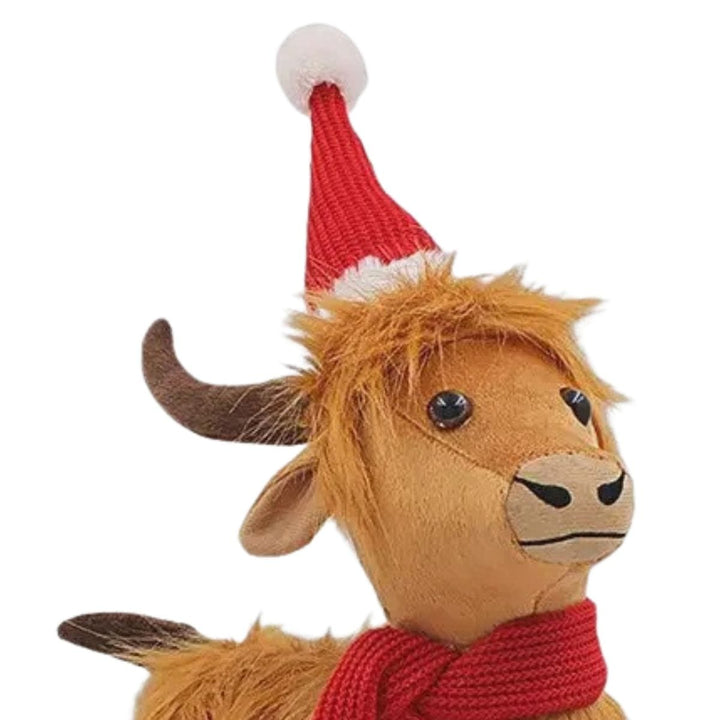 close up of highland cow figure wearing a knitted santa hat with plush horns and beaded eyes