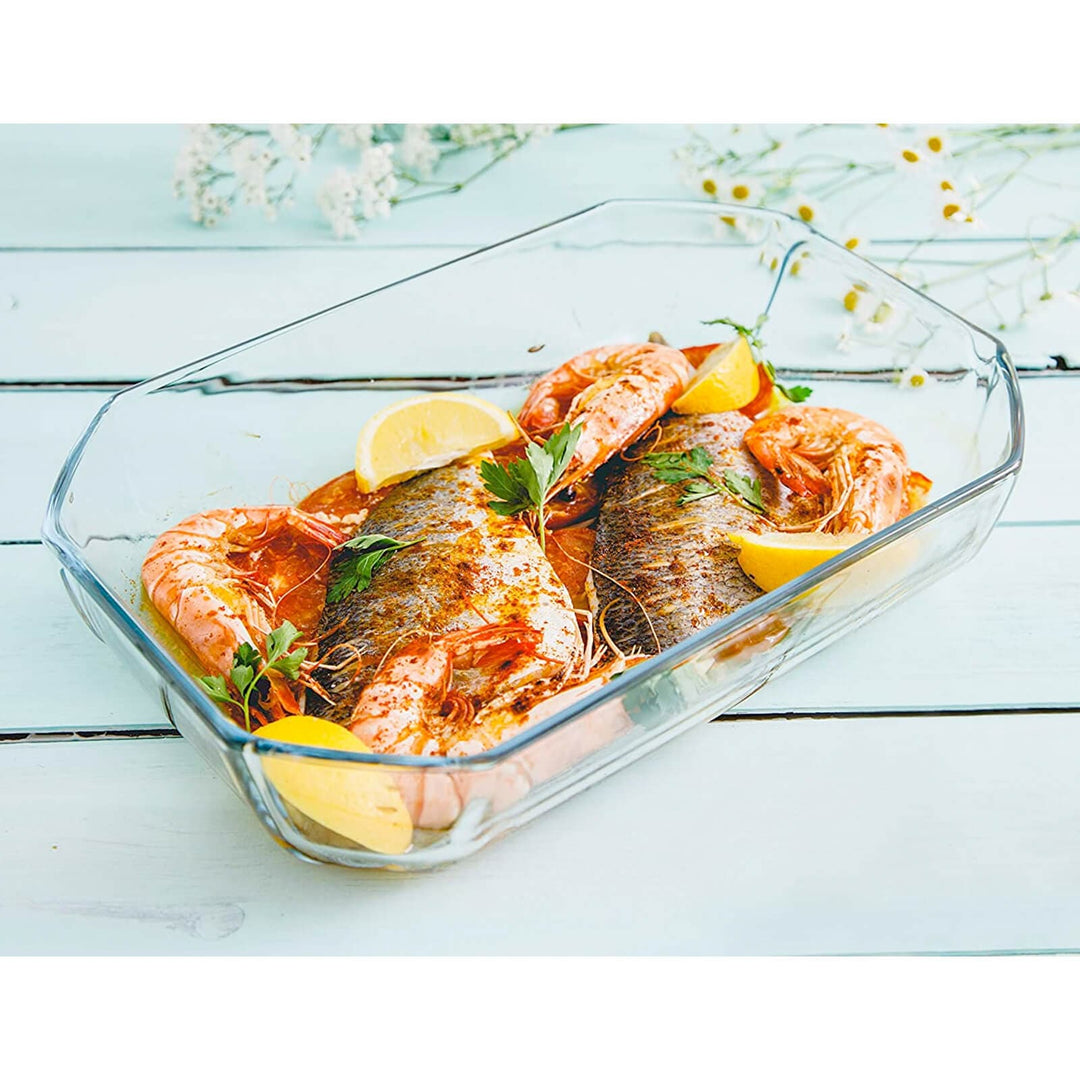 Pyrex Inspiration rectangular glass roasting dish with baked fish, langoustines and lemon on a wooden table