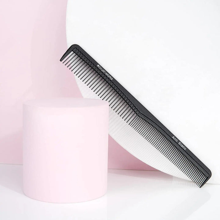 Black anti static hair comb presented on a pink display stand