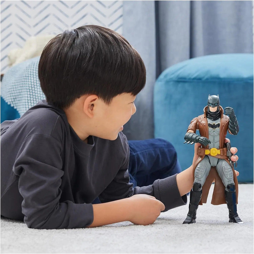 Boy playing with a Batman figure with a brown coat and batsuit