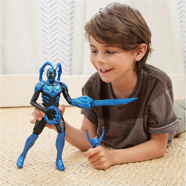 Boy playing with large Battle Mode Blue Beetle action figure on the floor