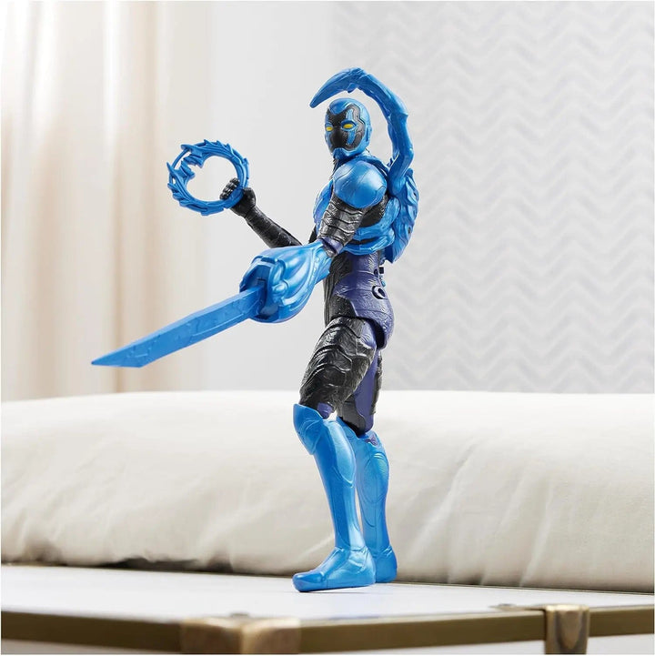 Large Blue Beetle action figure posed on a table with weapons uplifted