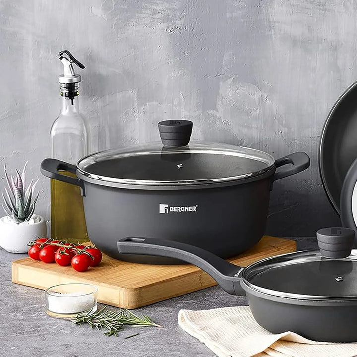 Bergner black casserole pot with glass lid, on a chopping board with tomatoes, olive oil and salt