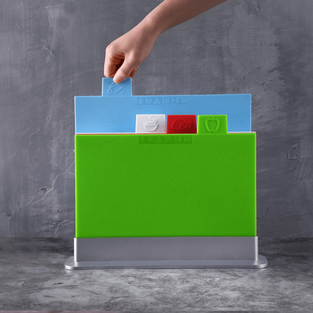 unidentified hand lifts blue 'fish' coded chopping board out of holder in kitchen