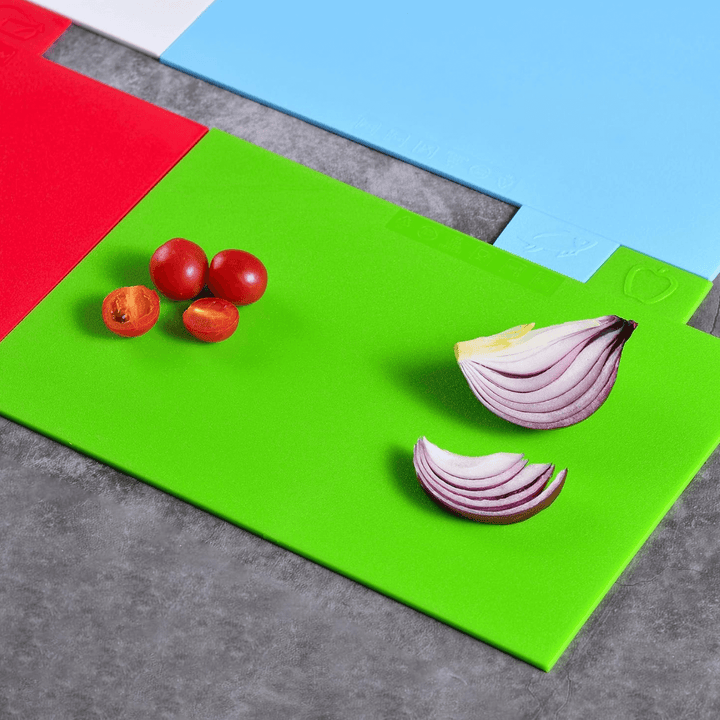 chopping boards laid flat on concrete worktop with sliced tomatoes and onion resting on top