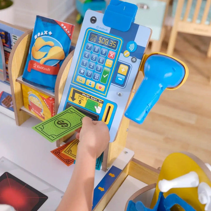 Child putting money into a checkout till with scanner