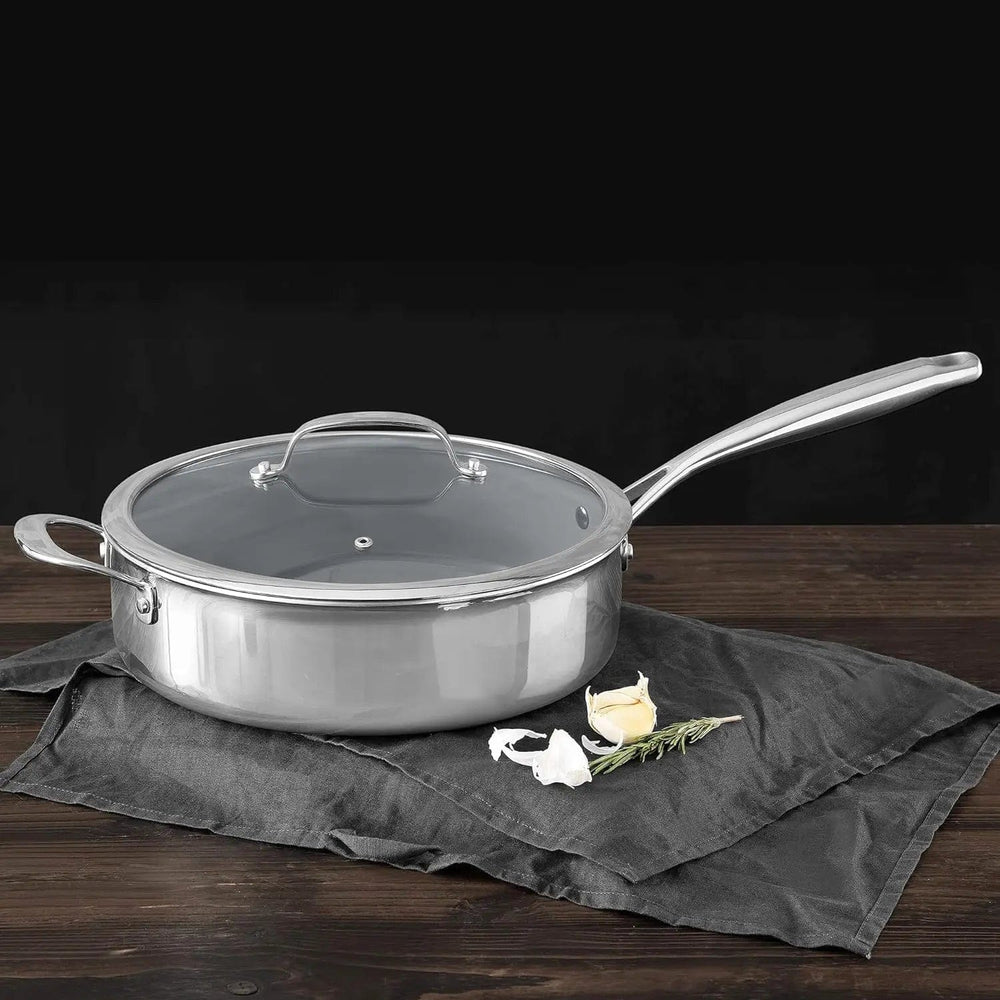 Large saute pan with helper handle, sitting on a wooden table with garlic and rosemary