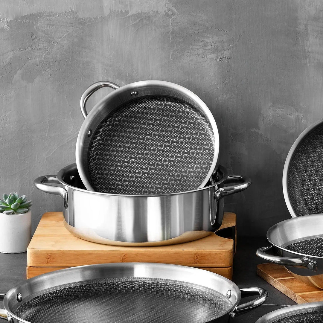 Polished stainless steel casserole pots on chopping boards in a kitchen