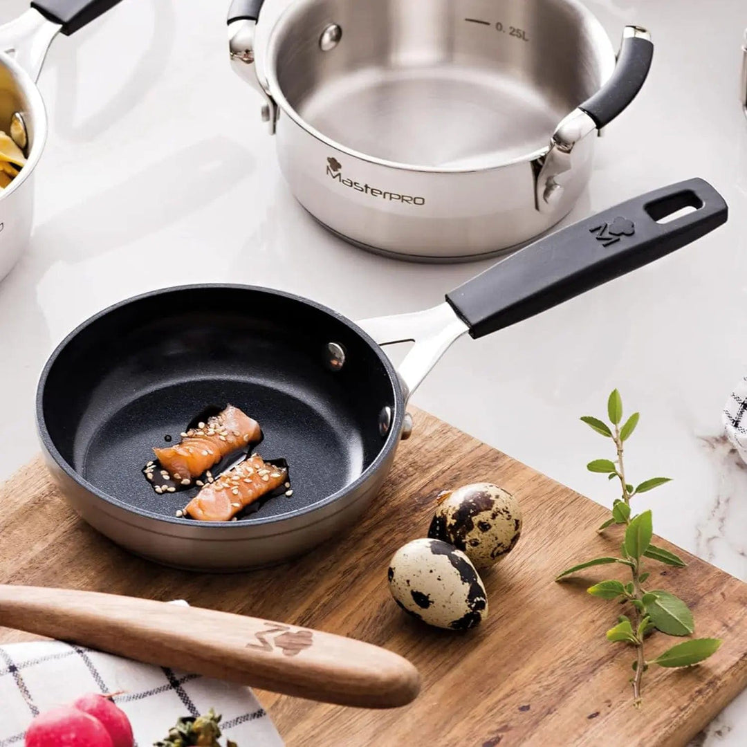 12cm little frying pan with sesame salmon slices on a chopping board, with quail eggs, herbs and a stock pot