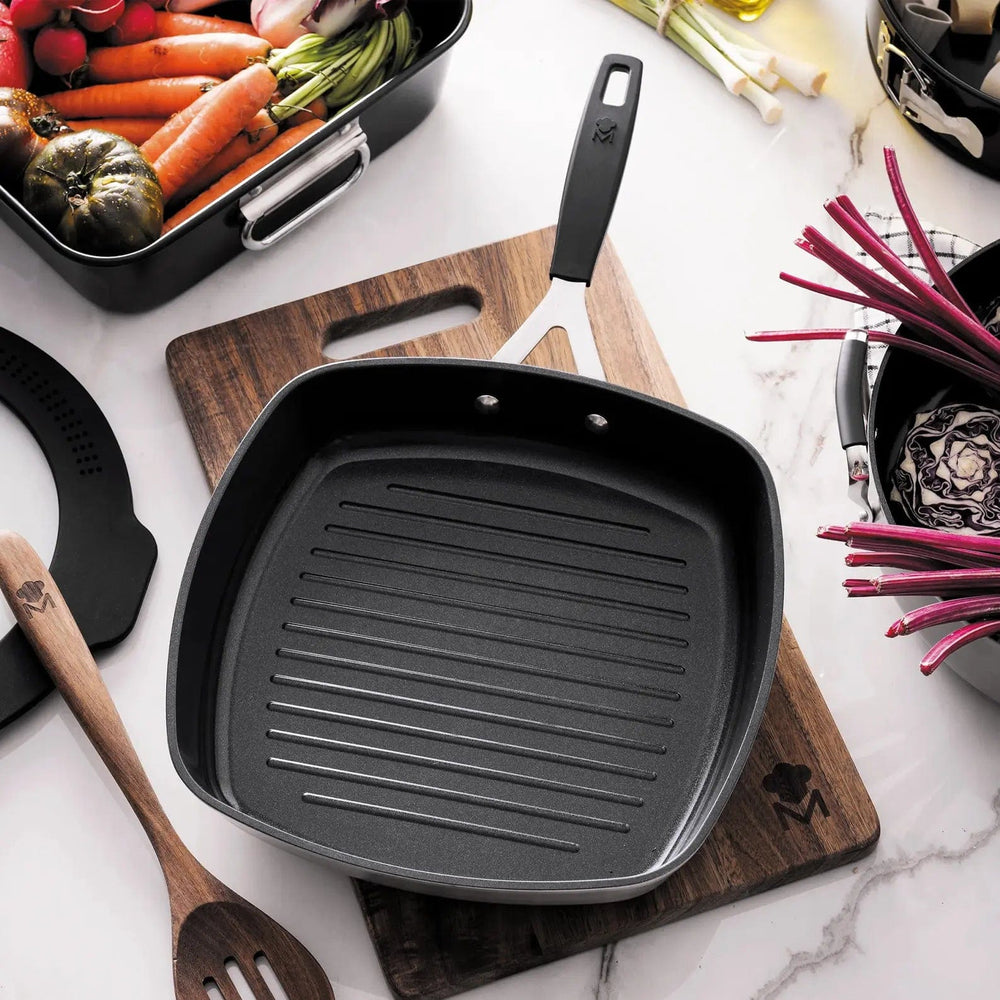 Silver and black grill pan on a wooden chopping board with food