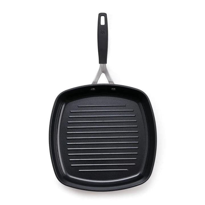 Overhead view of a black non-stick grilling pan with ridged surface to prevent sticking