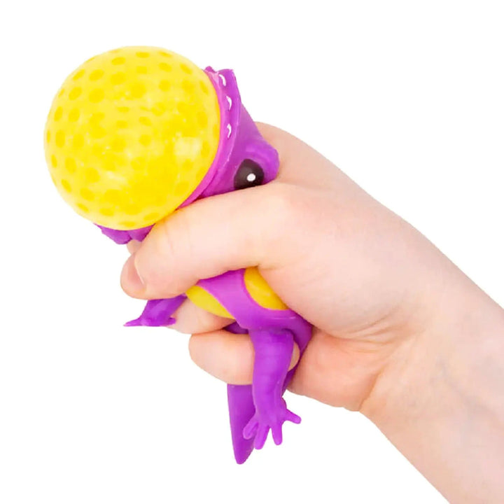 Hand squeezing a purple lizard ball figure for stress relief