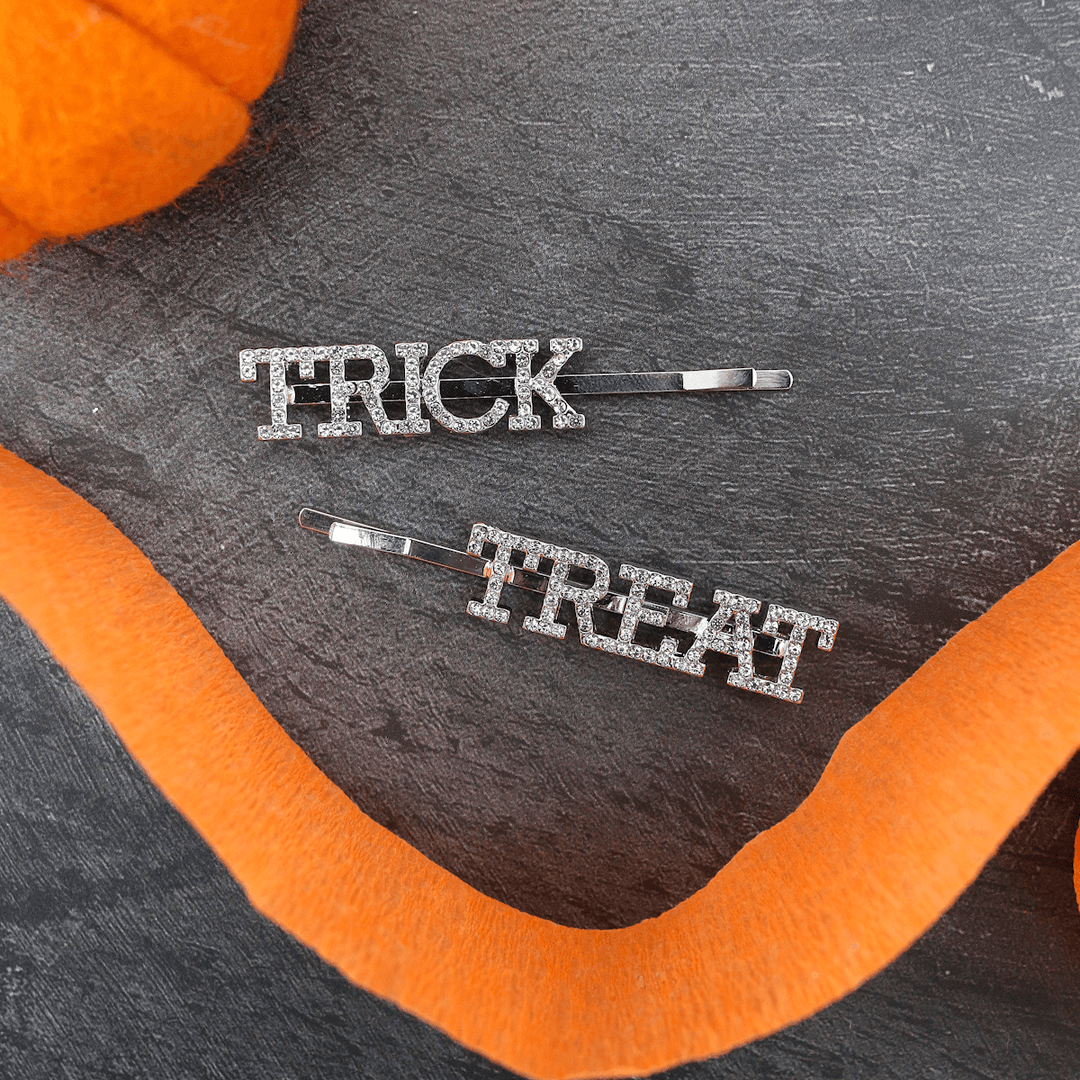 trick and treat slogan sparkly hair slides on black background with orange details