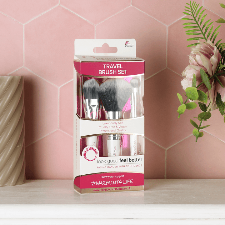 travel brush set on bathroom counter with flowers and candle