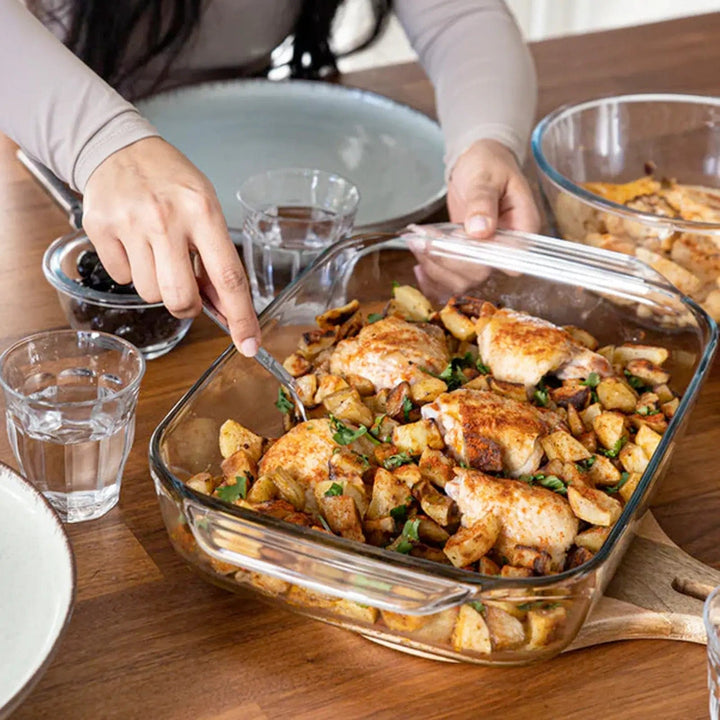 Person serving food from a Pyrex glass roasting dish