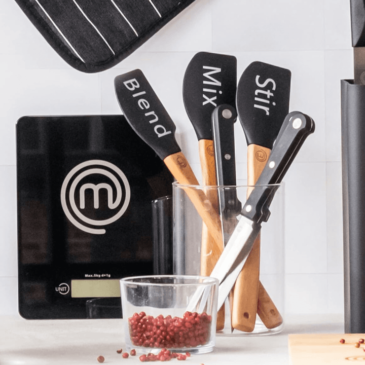 wooden spatulas in glass container in kitchen space featuring 'blend', 'mix' and 'stir' slogans