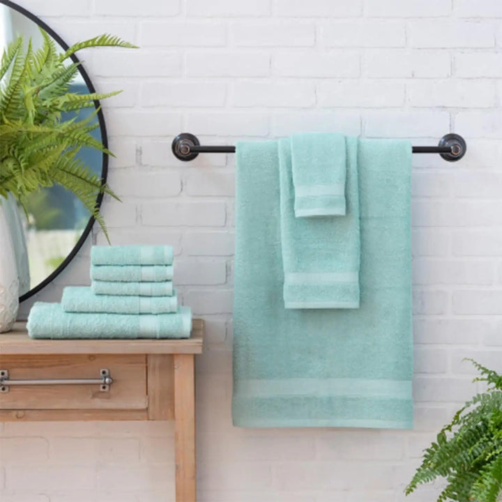 Set of 8 aqua coloured towels in a bathroom with mirror and plants