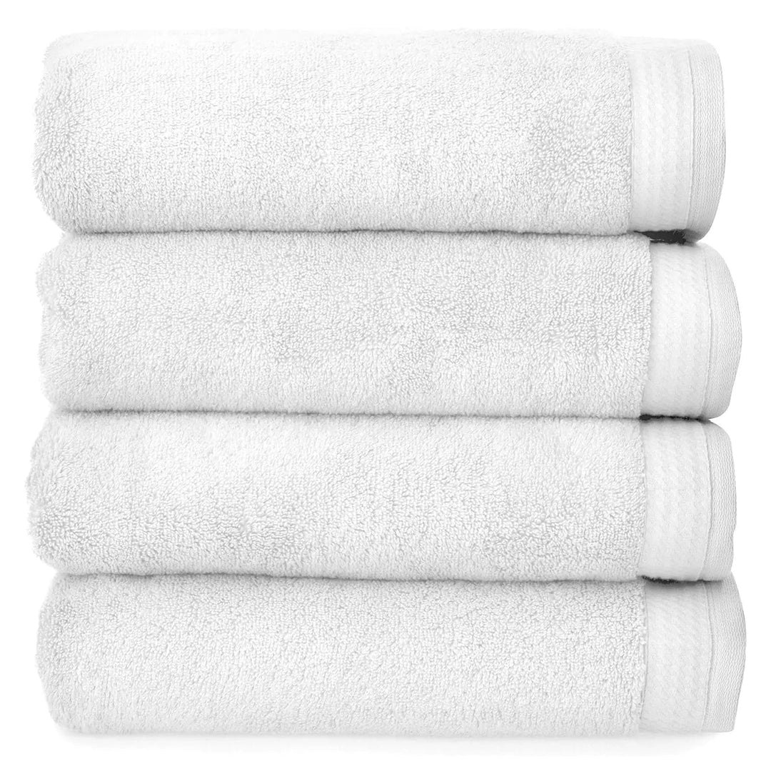 4 thick luxury white towels folded and piled up