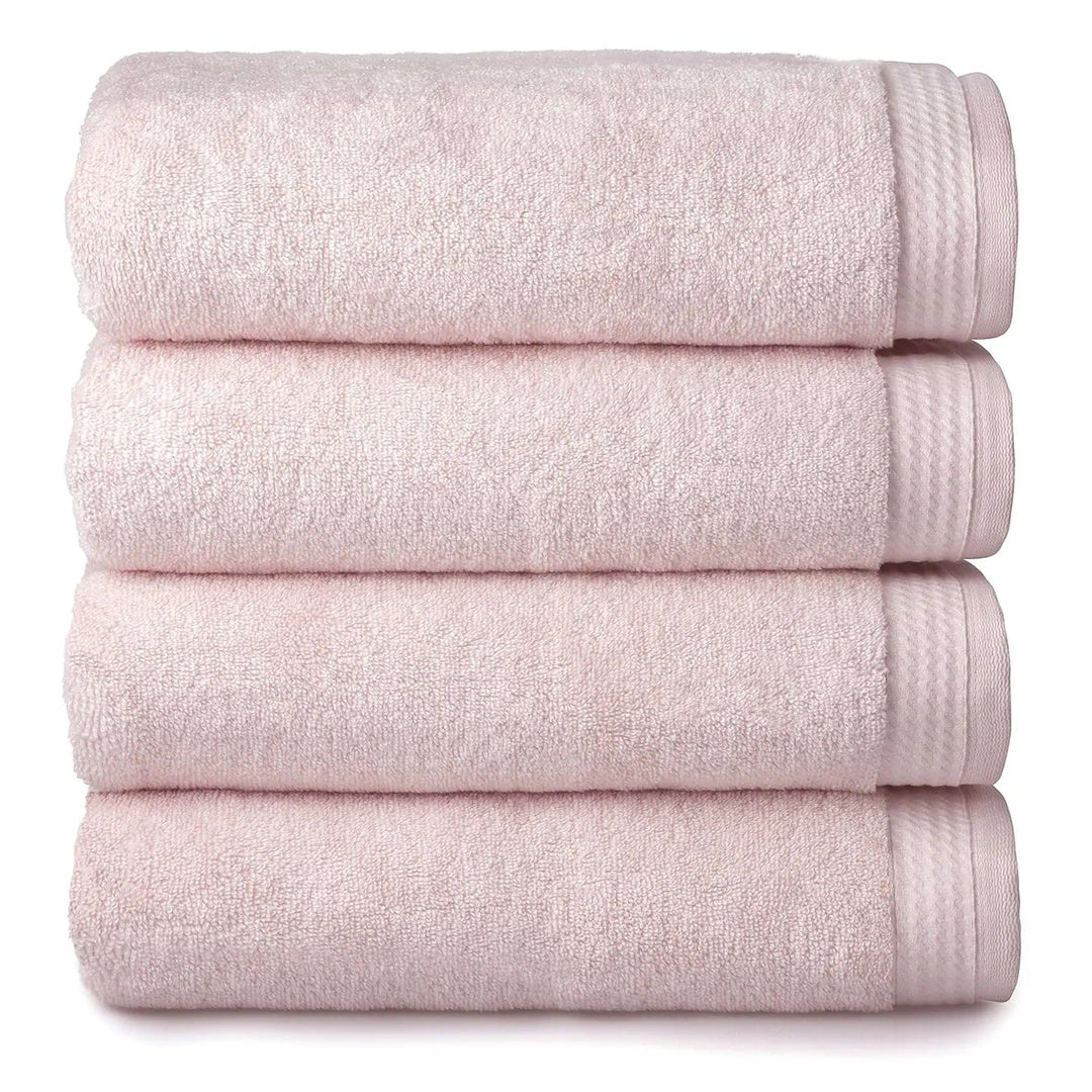 4 thick luxury blush pink towels folded and piled up