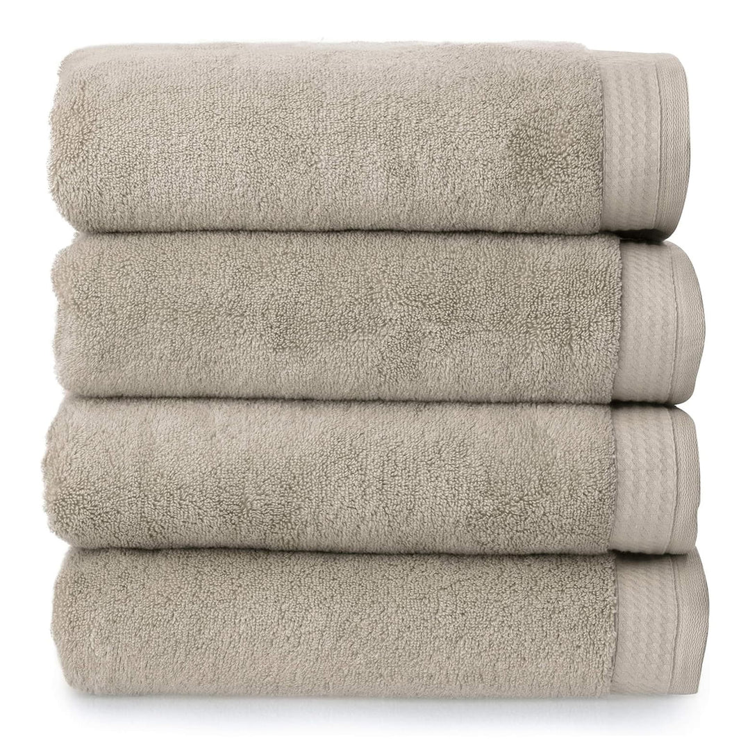 4 thick luxury almond beige towels folded and piled up