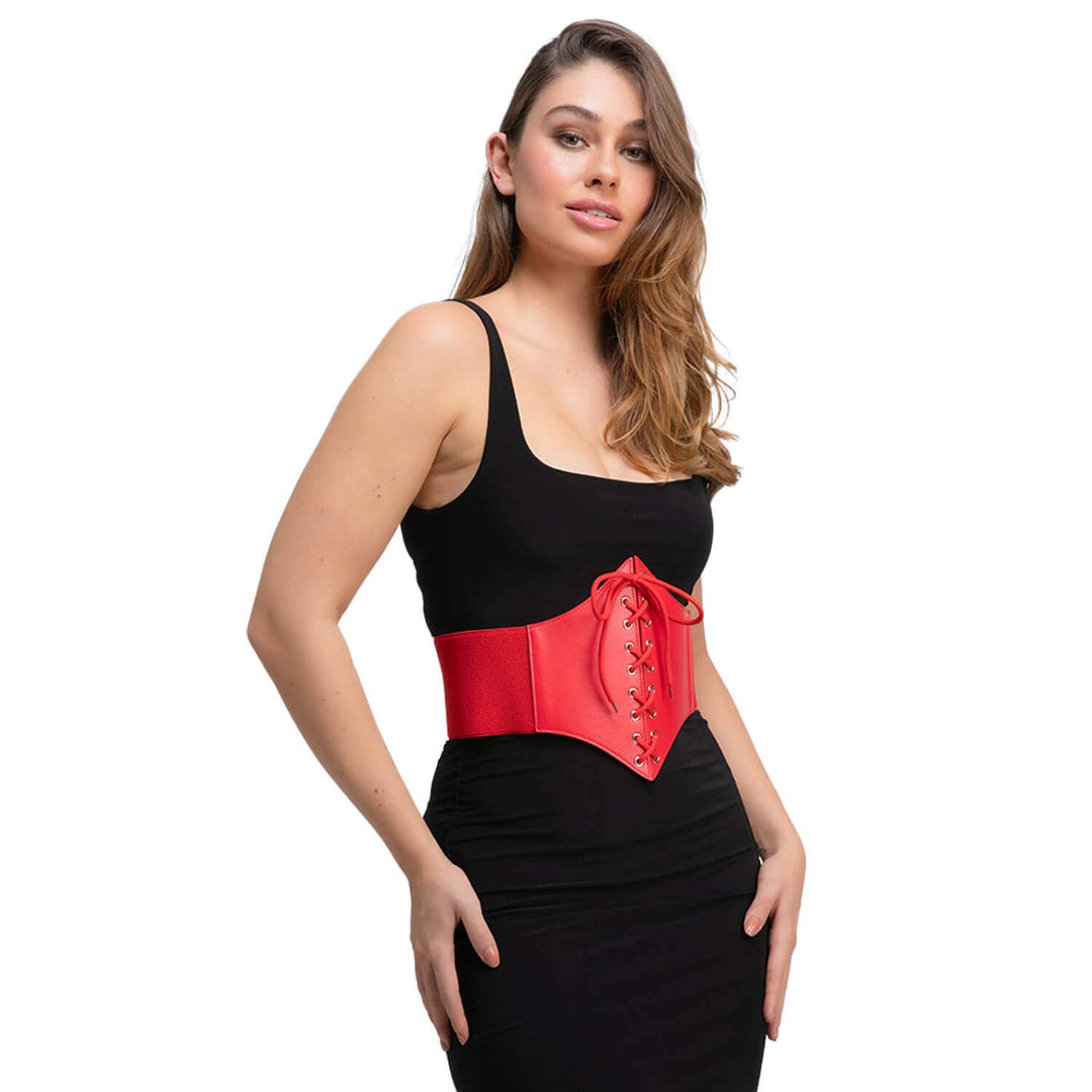 A woman wearing a red corset-style waist belt featuring lace-up front details, over a black top and trousers on a white background