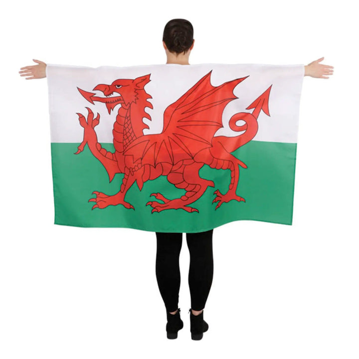 Man with arms outstretched and Welsh national flag cape