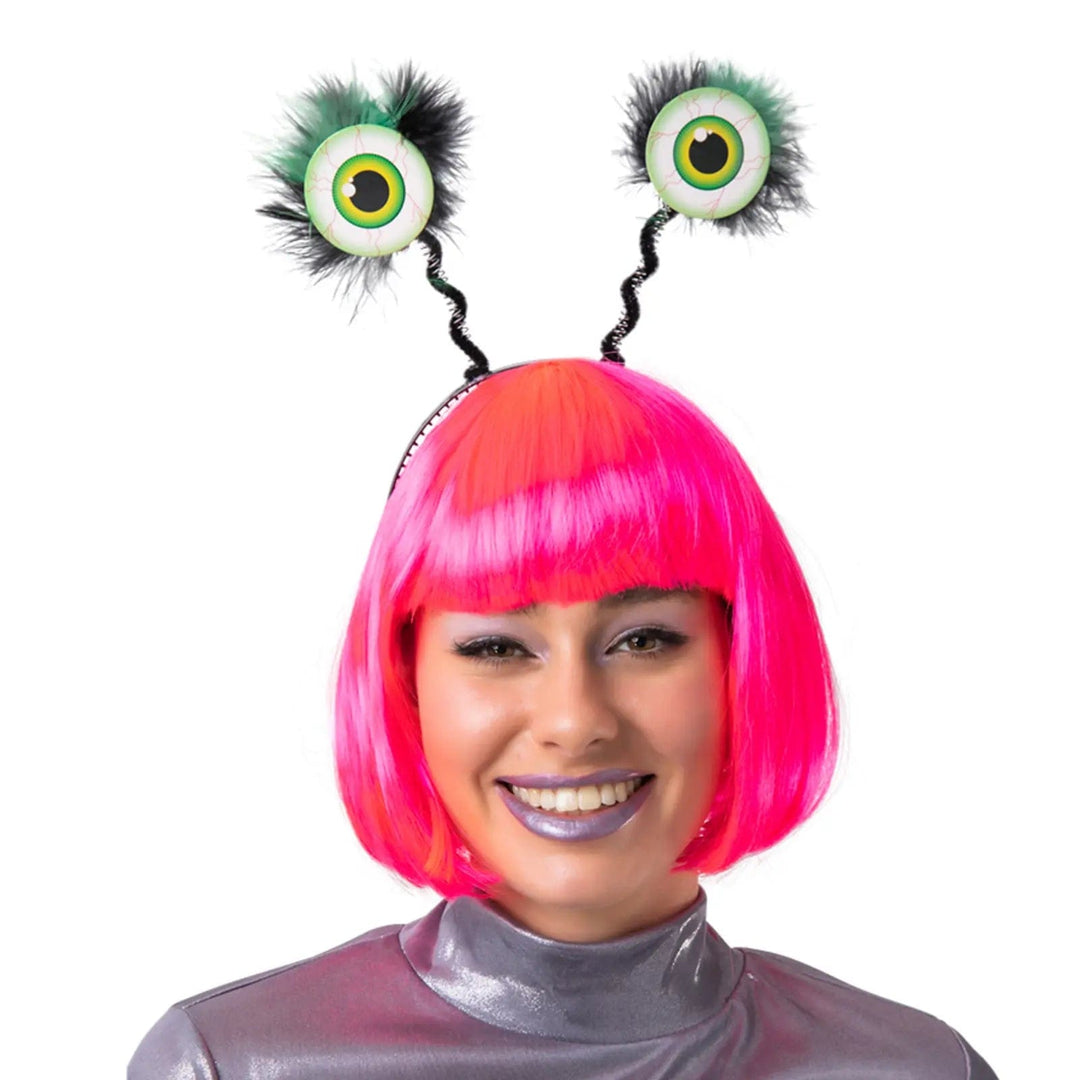 Lady wearing a bright pink wig and headband with large alien eyes on springs for fancy dress parties