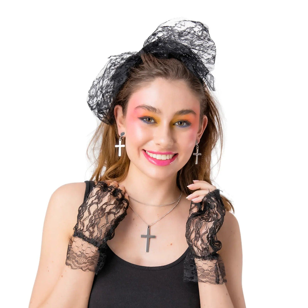 Female model wearing black lace hair tie, fingerless gloves, silver cross necklace with matching earrings for 80s fancy dress costumes