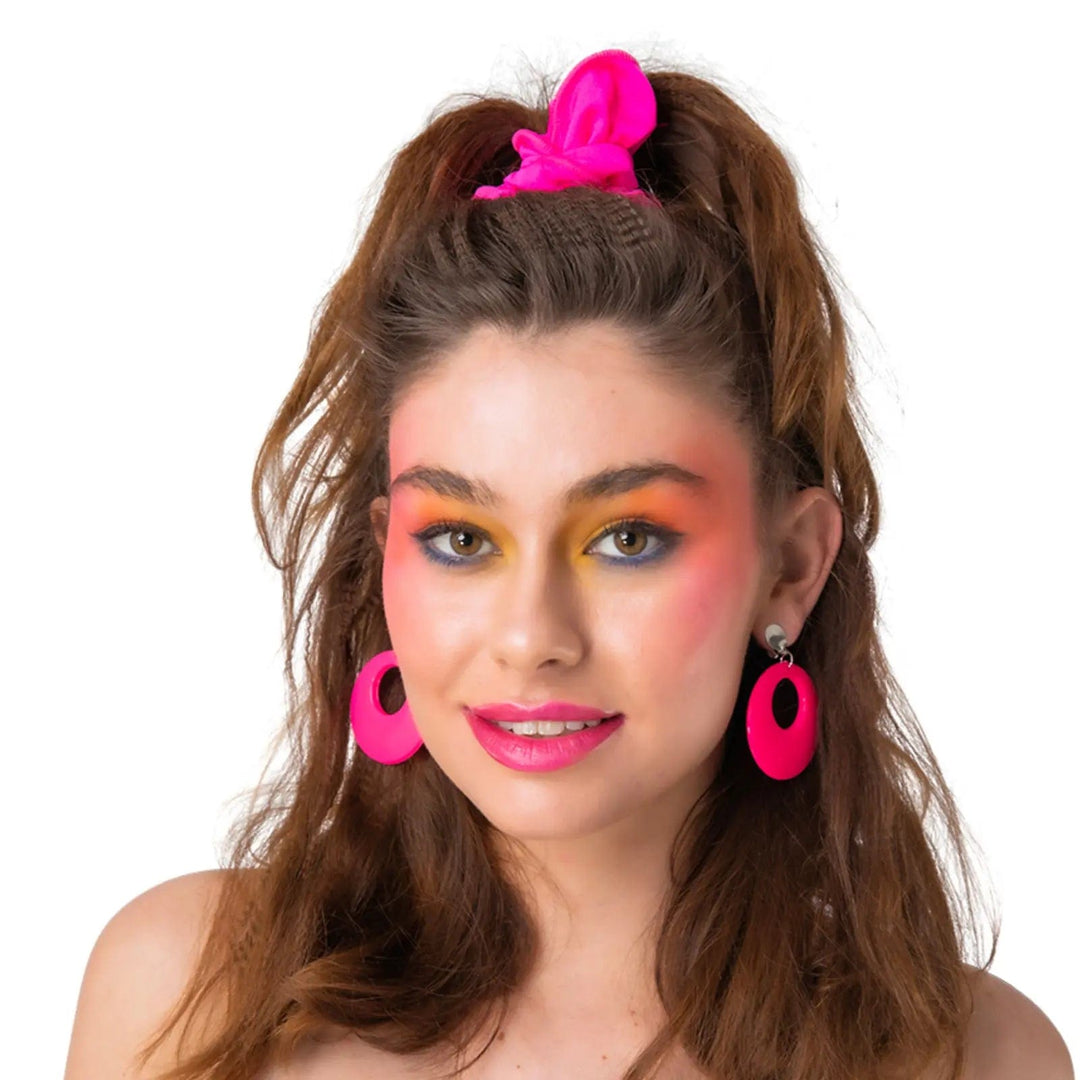 Lady wearing a pair of bright neon pink disc earrings for 80s fancy dress costumes