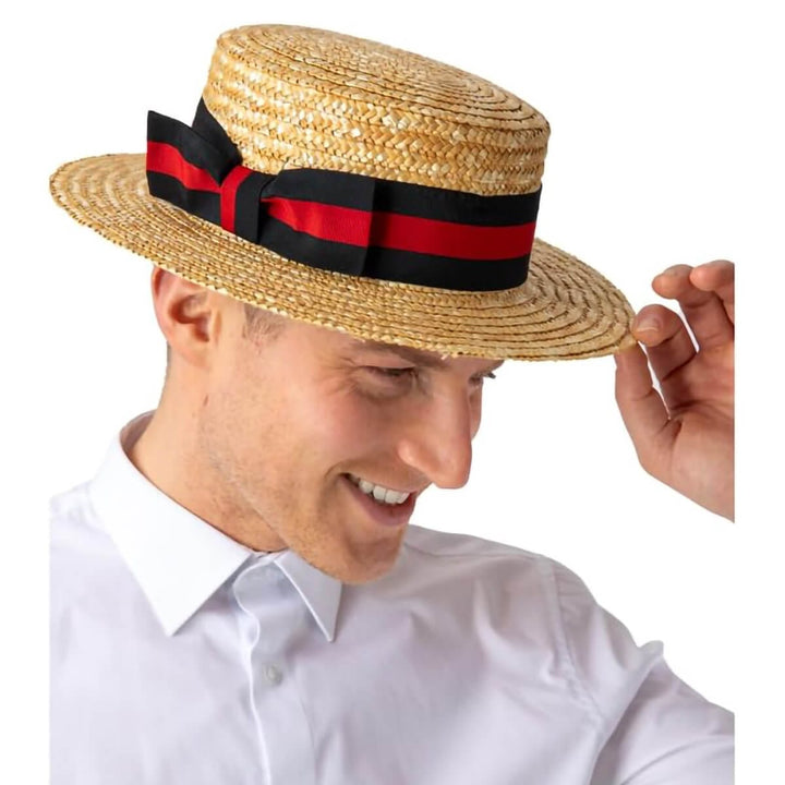 A man wearing a straw boater hat with a black and red ribbon band, shown from the chest up against a plain white background.