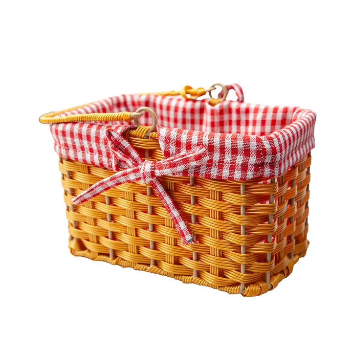 Side view of a small wicker basket with red and white checked lining and bow