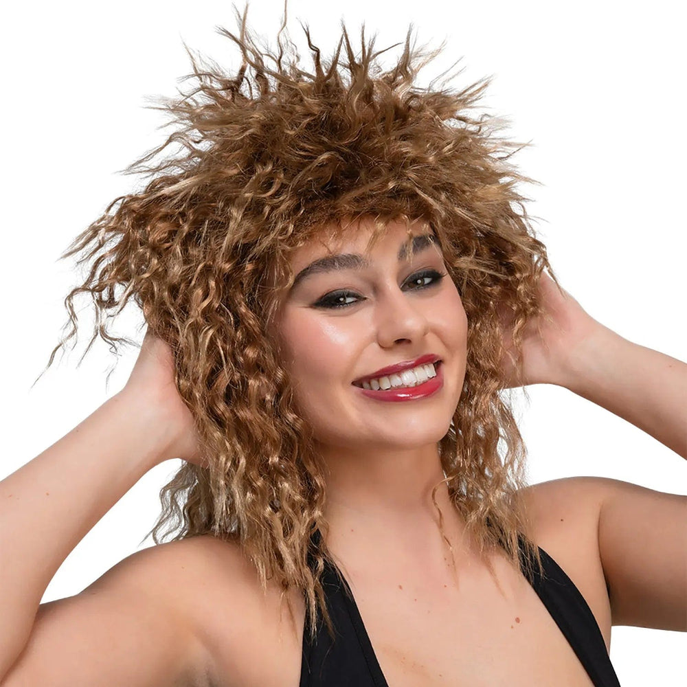 Young lady wearing a big brown curly hair wig for Tina Turner fancy dress costume